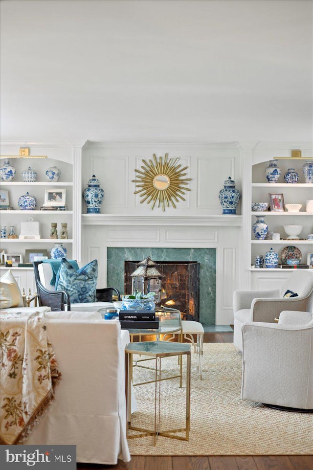 living area with built in features and a premium fireplace