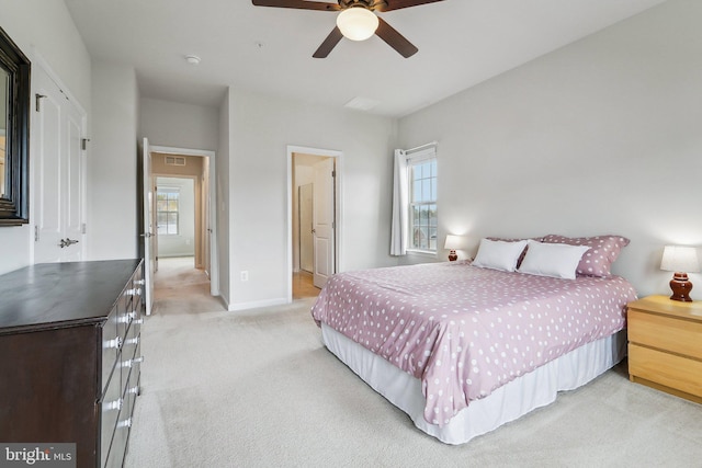 bedroom featuring light colored carpet, baseboards, and a ceiling fan