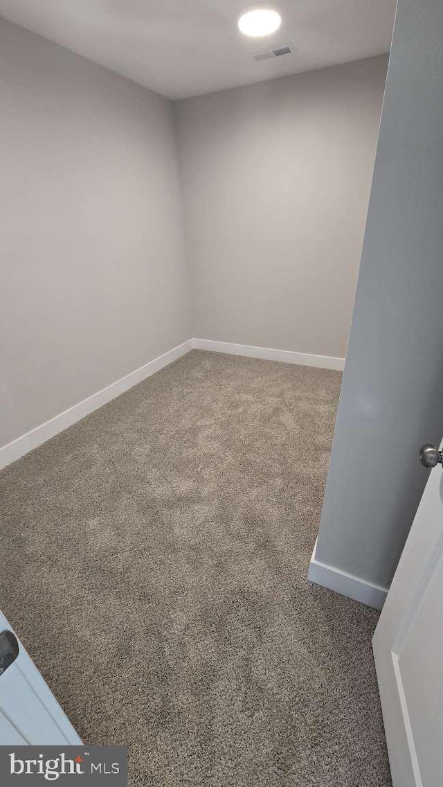 carpeted empty room featuring visible vents and baseboards