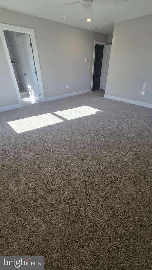 carpeted spare room featuring baseboards