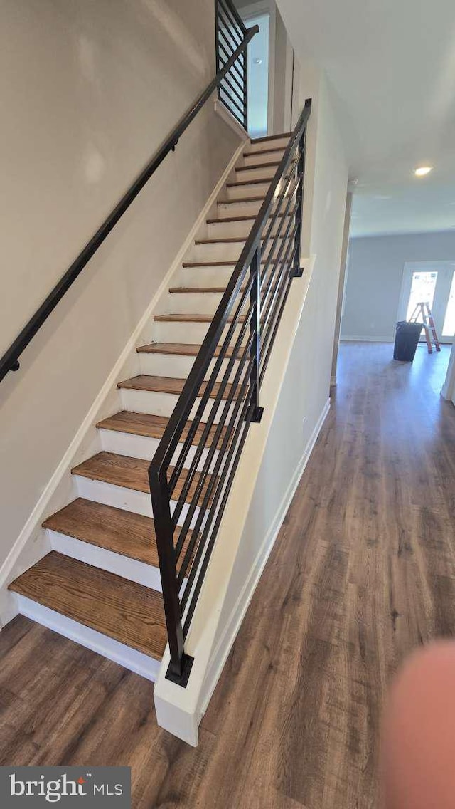 stairs featuring wood finished floors and baseboards