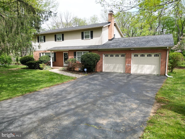 traditional-style home with a chimney, a front yard, a garage, brick siding, and aphalt driveway