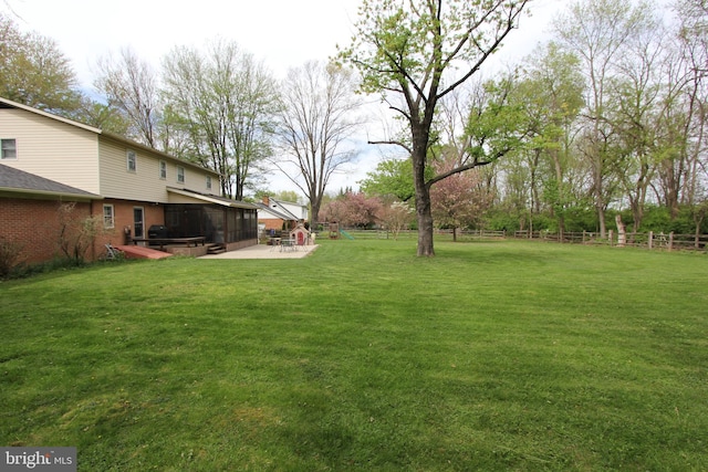 view of yard with a sunroom, fence, and a patio