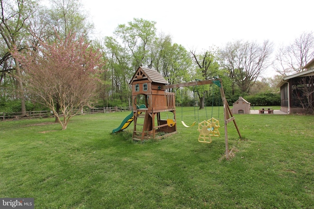 view of jungle gym with a storage unit, an outdoor structure, fence, and a yard