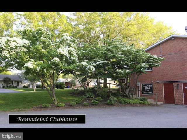 view of side of home featuring brick siding and a yard