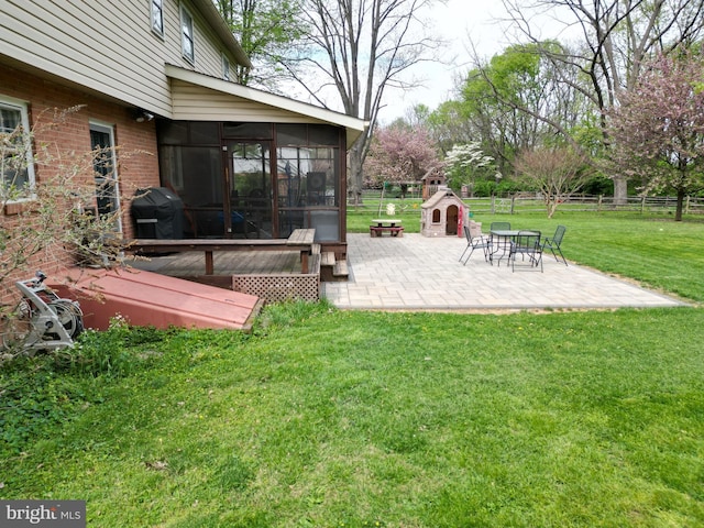 view of yard featuring a patio, fence, and a sunroom