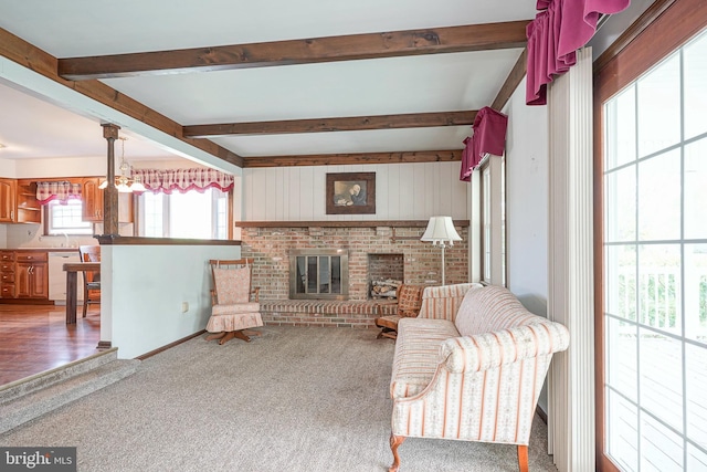 carpeted living area with beamed ceiling and a brick fireplace