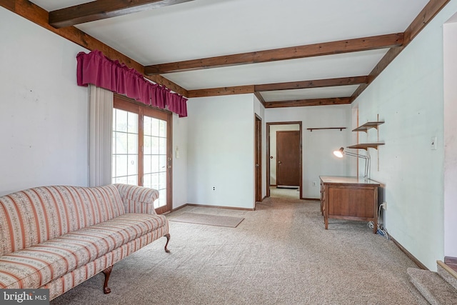 living area with beamed ceiling, light colored carpet, and baseboards