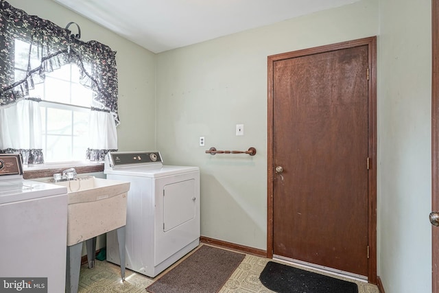 laundry area featuring washing machine and dryer, a sink, laundry area, and light floors