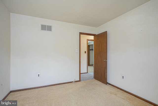carpeted spare room featuring visible vents and baseboards