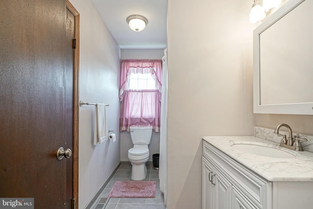 bathroom with toilet, tile patterned flooring, and vanity