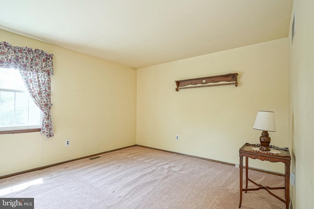 empty room featuring visible vents, carpet flooring, and baseboards