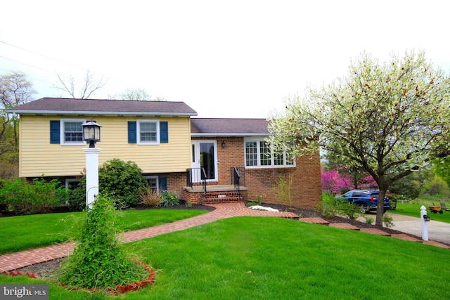 split level home with brick siding and a front lawn