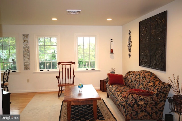 living room with visible vents, light wood-type flooring, baseboards, and recessed lighting