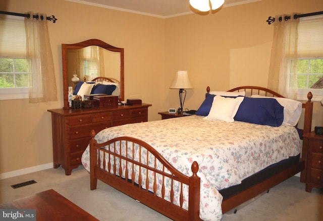 bedroom with baseboards, visible vents, ornamental molding, and light carpet