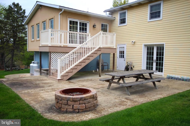 rear view of property featuring stairway, a deck, an outdoor fire pit, and a patio