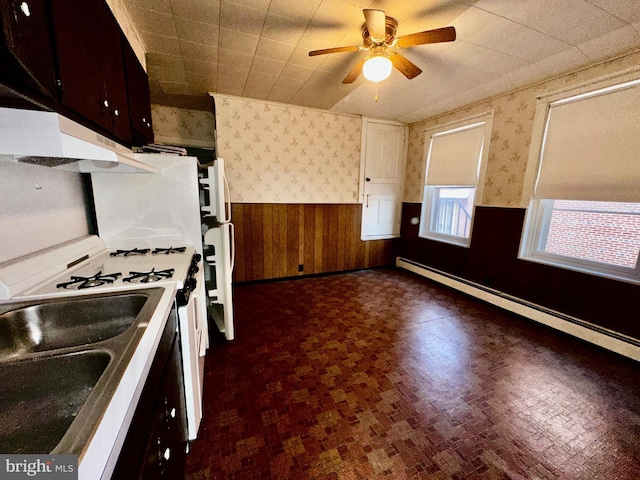 2214 Noble St, Reading, PA 19609 - kitchen featuring wainscoting, wallpapered walls, under cabinet range hood, a baseboard heating unit, and range with gas cooktop