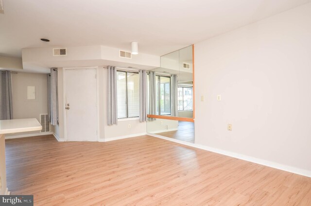 empty room featuring light wood finished floors and baseboards