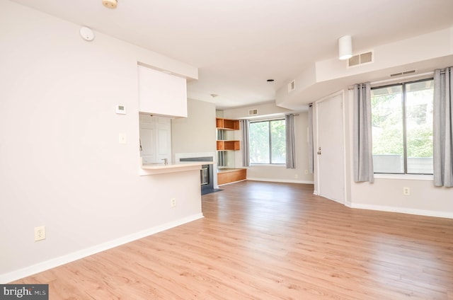 unfurnished living room featuring light wood-type flooring and baseboards