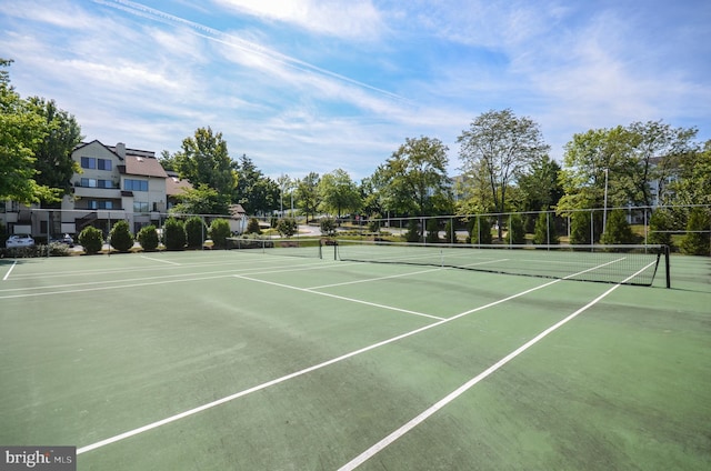 view of tennis court featuring community basketball court and fence