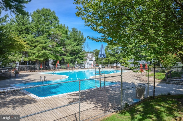 community pool with fence and a patio area