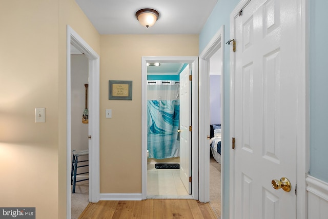 hall featuring baseboards and light wood-style floors