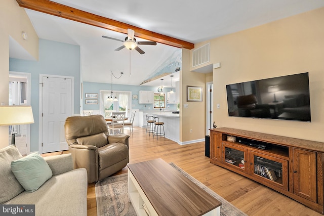 living room featuring visible vents, baseboards, ceiling fan, vaulted ceiling with beams, and light wood-type flooring