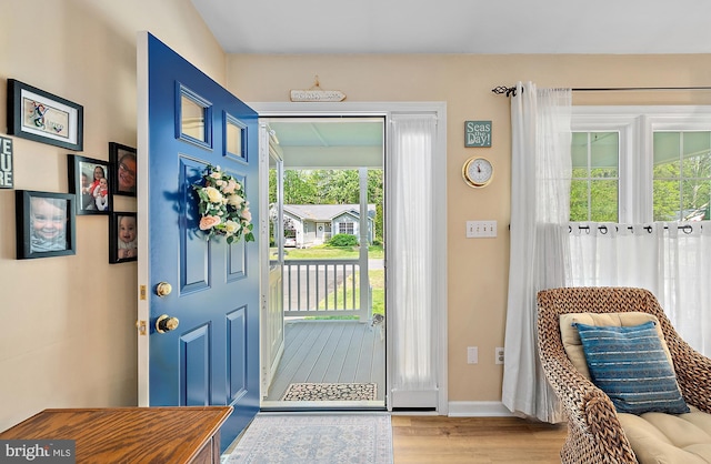 doorway with baseboards and wood finished floors