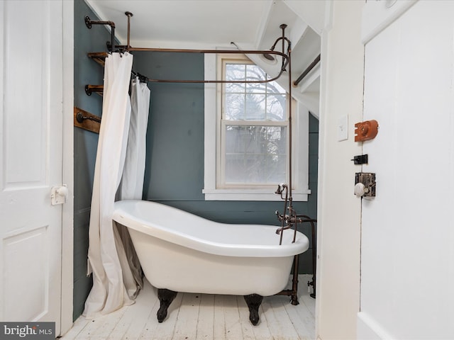 full bathroom with a freestanding bath and wood finished floors