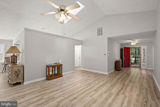 unfurnished living room featuring a ceiling fan, light wood-style flooring, a textured ceiling, baseboards, and high vaulted ceiling