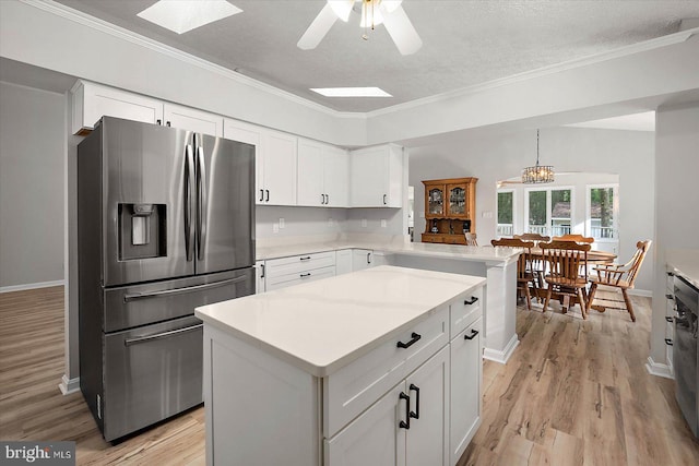 kitchen with stainless steel refrigerator with ice dispenser, light wood-style floors, white cabinetry, ornamental molding, and a textured ceiling