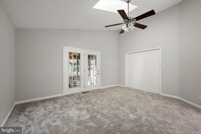 unfurnished bedroom featuring carpet, high vaulted ceiling, a textured ceiling, baseboards, and a ceiling fan