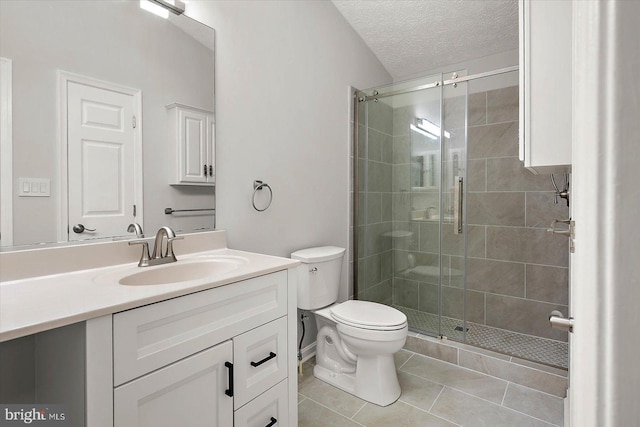 full bath with a stall shower, toilet, tile patterned floors, vanity, and a textured ceiling