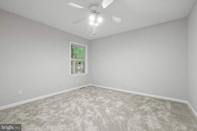 empty room featuring carpet flooring, ceiling fan, and baseboards