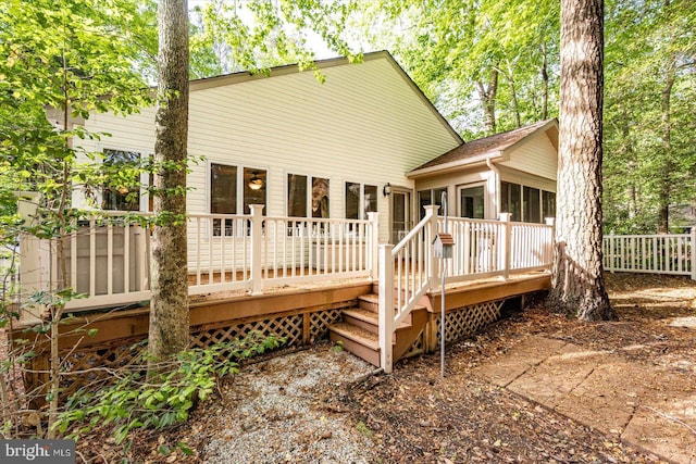 rear view of property with a wooden deck and fence