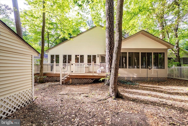 back of property with a sunroom and a deck