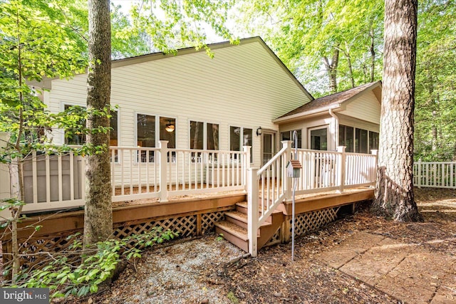 rear view of house with a deck and a sunroom