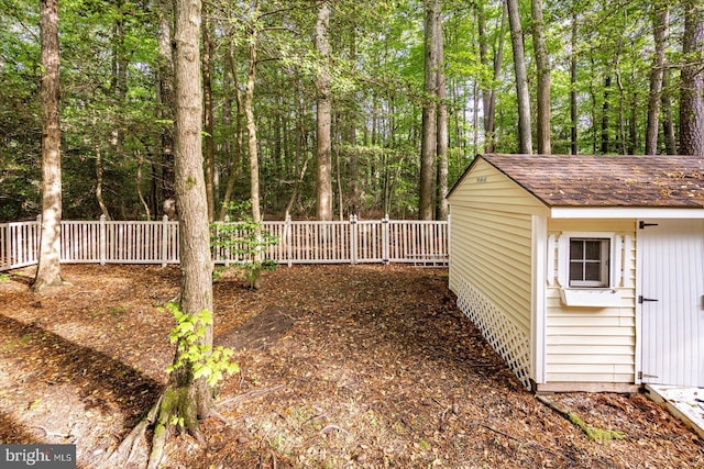 view of yard featuring fence, a shed, and an outdoor structure