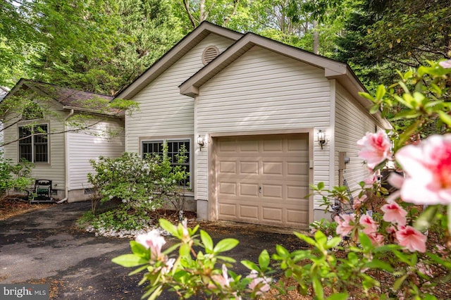 view of front of home featuring an attached garage and asphalt driveway