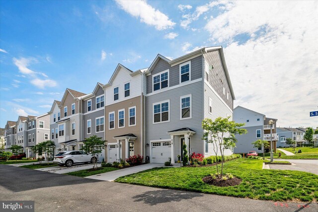 418 S Seaway Ct, Cambridge, MD 21613 - townhome / multi-family property featuring a residential view, an attached garage, driveway, and a front lawn