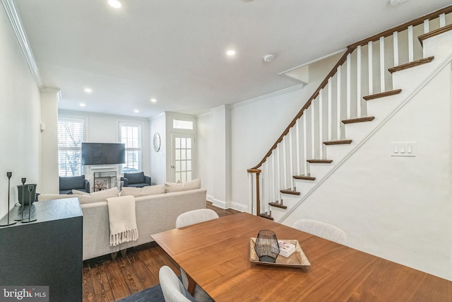 dining space featuring dark wood-type flooring, recessed lighting, ornamental molding, and stairway