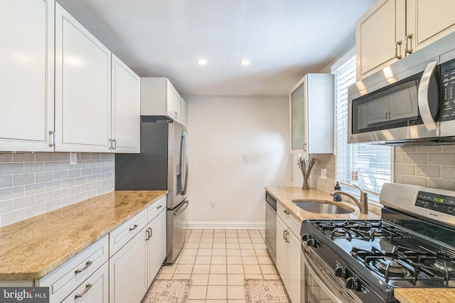 kitchen featuring a sink, baseboards, plenty of natural light, and stainless steel appliances