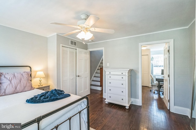 bedroom with dark wood-type flooring, visible vents, a closet, and crown molding