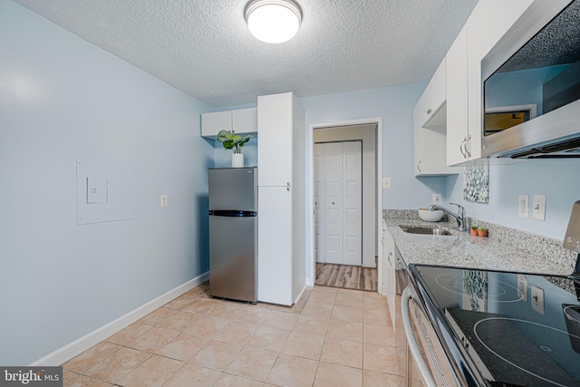 2311 Pimmit Dr Unit 1102, Falls Church, VA 22043 - kitchen with appliances with stainless steel finishes, a sink, a textured ceiling, white cabinetry, and light stone countertops