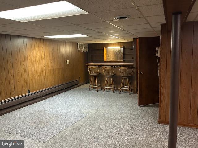 355 George St, Hanover, PA 17331 - indoor dry bar with a drop ceiling, a baseboard radiator, wooden walls, and carpet