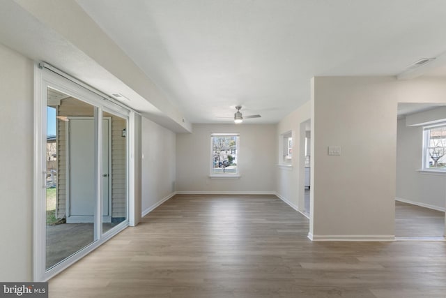 empty room with ceiling fan, baseboards, and wood finished floors