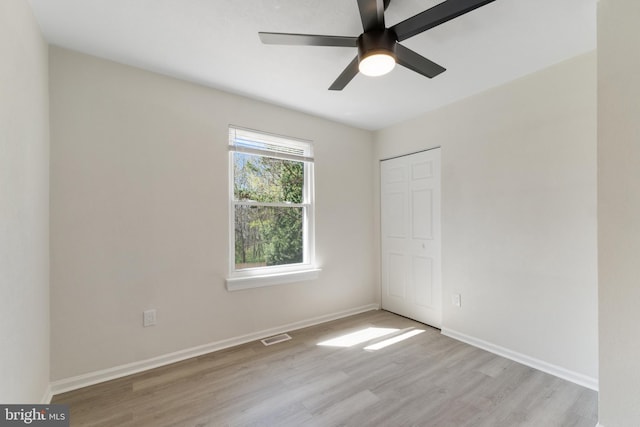 spare room with visible vents, baseboards, light wood finished floors, and a ceiling fan
