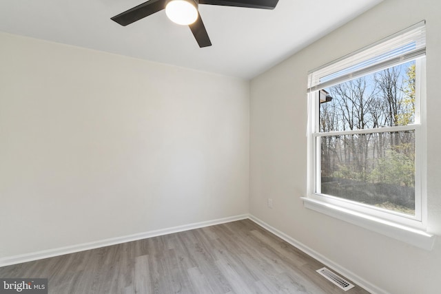 unfurnished room with visible vents, baseboards, a ceiling fan, and wood finished floors