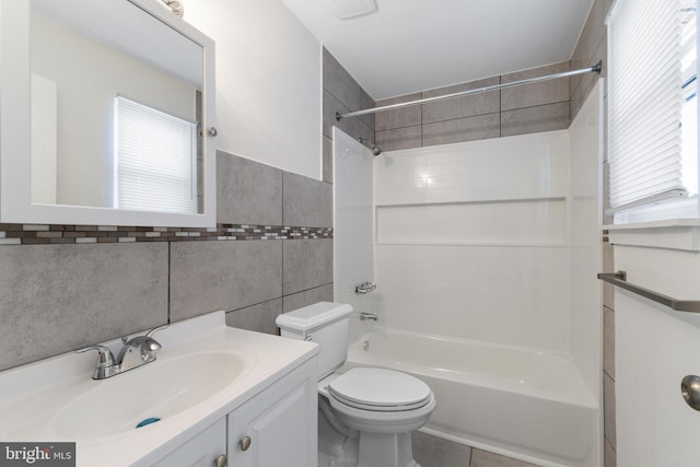 bathroom featuring shower / washtub combination, toilet, tile walls, vanity, and tile patterned flooring