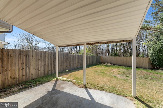 view of yard featuring a carport, a fenced backyard, and a patio